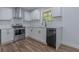 Modern kitchen with stainless steel appliances, white cabinets, and wood-look flooring at 5207 Dixie Lake Rd, Union City, GA 30291