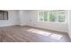 Sunlit living room showcasing wood-look floors and a large window, creating a warm and inviting atmosphere at 5207 Dixie Lake Rd, Union City, GA 30291