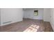 Spacious living room with wood-look floors, white walls, and natural light streaming through the window at 5207 Dixie Lake Rd, Union City, GA 30291