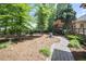 Landscaped backyard featuring a brick pathway leading to a wooden deck at 569 Fairway Dr, Woodstock, GA 30189