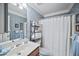 Well-lit bathroom with floral wallpaper, a shower, and a large mirror over the vanity at 569 Fairway Dr, Woodstock, GA 30189