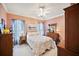 Charming bedroom with a ceiling fan and a light color scheme with a floral bedspread at 569 Fairway Dr, Woodstock, GA 30189