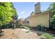 Home's rear exterior showcasing a wooden deck and lush landscaping at 569 Fairway Dr, Woodstock, GA 30189