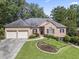 Charming brick home featuring a manicured front yard and an attached two-car garage at 569 Fairway Dr, Woodstock, GA 30189