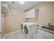 Functional laundry room with utility sink, washer and dryer, and overhead storage at 569 Fairway Dr, Woodstock, GA 30189
