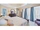 A bright main bedroom featuring a tray ceiling, large windows, and a cozy sitting area at 569 Fairway Dr, Woodstock, GA 30189