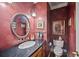 Stylish powder room with granite counters, oval mirror, and decorative fixtures at 569 Fairway Dr, Woodstock, GA 30189