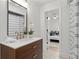 Modern bathroom featuring a wood vanity, elegant fixtures, and a view into the adjacent bedroom at 1494 May Se Ave, Atlanta, GA 30316