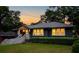Inviting home exterior at dusk with glowing windows, a dark exterior, and luscious green lawn at 1494 May Se Ave, Atlanta, GA 30316