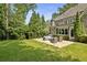Green backyard featuring a cozy patio with a seating area, surrounded by a well-maintained lawn and mature trees at 157 Lake Forrest Ne Ln, Atlanta, GA 30342
