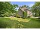 Expansive backyard with mature trees, a well-kept lawn, and a comfortable patio area, offering a private outdoor oasis at 157 Lake Forrest Ne Ln, Atlanta, GA 30342