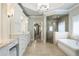 Spa-like bathroom featuring a soaking tub, glass-enclosed shower, and double vanities with white cabinetry at 157 Lake Forrest Ne Ln, Atlanta, GA 30342