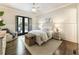 Bright bedroom features neutral paint, wainscotting, hardwood floors, and door leading to outdoor deck at 157 Lake Forrest Ne Ln, Atlanta, GA 30342