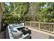 Outdoor deck area with comfortable seating surrounded by lush greenery and trees at 157 Lake Forrest Ne Ln, Atlanta, GA 30342