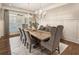Formal dining area featuring a long wooden table, upholstered chairs, and classic chandeliers with wainscoting at 157 Lake Forrest Ne Ln, Atlanta, GA 30342