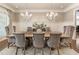 Elegant dining room with decorative wallpaper, wainscoting, modern chandeliers, and seating for six at 157 Lake Forrest Ne Ln, Atlanta, GA 30342