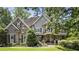 A stone and brick home with a manicured front lawn and mature trees offering curb appeal at 157 Lake Forrest Ne Ln, Atlanta, GA 30342