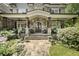 Charming front porch with stone columns, a swing, and comfortable seating, perfect for relaxing at 157 Lake Forrest Ne Ln, Atlanta, GA 30342