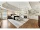 Luxurious main bedroom with a tray ceiling, fireplace, hardwood floors, and custom built-in shelving at 157 Lake Forrest Ne Ln, Atlanta, GA 30342