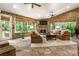 Cozy sunroom with exposed brick, large windows and natural light, fireplace, and a ceiling fan at 157 Lake Forrest Ne Ln, Atlanta, GA 30342