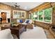 Inviting sunroom with brick walls, wood-plank ceiling, and large windows offering scenic backyard views and natural light at 157 Lake Forrest Ne Ln, Atlanta, GA 30342