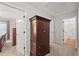 Hallway with a large wooden armoire, doors leading to rooms, and neutral carpeting at 2995 Barimore, Dacula, GA 30019