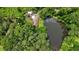 Aerial shot showcases a home nestled among trees alongside a serene pond, offering natural beauty and privacy at 347 Oakhurst Dr, Marietta, GA 30066