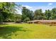 Large backyard with well-maintained lawn, mature trees, and a carport at 347 Oakhurst Dr, Marietta, GA 30066