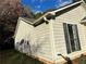 Vinyl siding exterior with a single window and satellite dish, featuring a well-manicured lawn at 1120 Northern Run, Stockbridge, GA 30281