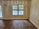 Bright living room with a large window for natural light with dark laminate flooring at 1120 Northern Run, Stockbridge, GA 30281