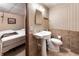 Basement bathroom with tile flooring, pedestal sink, and toilet at 11270 Stroup Road, Roswell, GA 30075