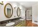 Bathroom featuring dual sinks with marble countertops and decorative mirrors at 11270 Stroup Road, Roswell, GA 30075