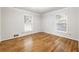 Bright bedroom with hardwood floors and two windows overlooking the outside at 11270 Stroup Road, Roswell, GA 30075