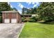 Brick home with two-car garage and lots of curb appeal, surrounded by mature trees and a well-maintained lawn at 11270 Stroup Road, Roswell, GA 30075