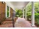 Covered front porch with brick accents, elegant columns, and a cozy atmosphere at 11270 Stroup Road, Roswell, GA 30075