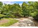 View of a charming home with a circular driveway, mature trees, and a well-kept lawn at 11270 Stroup Road, Roswell, GA 30075