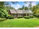 Charming one-story brick home featuring a well-manicured lawn and lovely landscaping at 11270 Stroup Road, Roswell, GA 30075