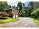 Exterior view of a detached brick two-car garage surrounded by trees and a circular driveway at 11270 Stroup Road, Roswell, GA 30075