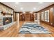 Living room with hardwood floors, wood-paneled walls, a stone fireplace, and built-in display cabinets at 11270 Stroup Road, Roswell, GA 30075