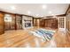 Living room featuring hardwood floors, wood-paneled walls, built-in bookcases, and a stone fireplace at 11270 Stroup Road, Roswell, GA 30075