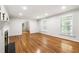 Open living room with hardwood floors, a fireplace, and an open doorway to another room at 11270 Stroup Road, Roswell, GA 30075