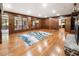 Spacious living room featuring hardwood floors, wood-paneled walls, large windows, and a stone fireplace at 11270 Stroup Road, Roswell, GA 30075