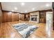 Cozy living room featuring hardwood floors, wood-paneled walls, built-in bookcases, and a stone fireplace at 11270 Stroup Road, Roswell, GA 30075