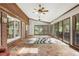 This sun room has brick walls, tile floors, a ceiling fan, and lots of natural light at 11270 Stroup Road, Roswell, GA 30075