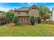 Large backyard with a view of the home's exterior featuring green lawns and mature trees at 1637 Willow Way, Woodstock, GA 30188