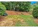 Well-manicured backyard featuring a gentle slope, mature trees, and natural landscaping at 1637 Willow Way, Woodstock, GA 30188