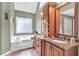 Bathroom featuring a soaking tub and double sinks in an elegant Primary bath at 1637 Willow Way, Woodstock, GA 30188
