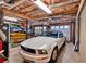 Well-lit garage showcasing a white sports car, storage, and exposed wooden ceiling rafters at 1637 Willow Way, Woodstock, GA 30188