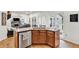 Open concept kitchen island with stainless steel appliances, breakfast bar, and view into living space at 1637 Willow Way, Woodstock, GA 30188