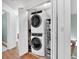 Laundry closet featuring a stacked washer and dryer, with storage shelves for supplies at 1637 Willow Way, Woodstock, GA 30188